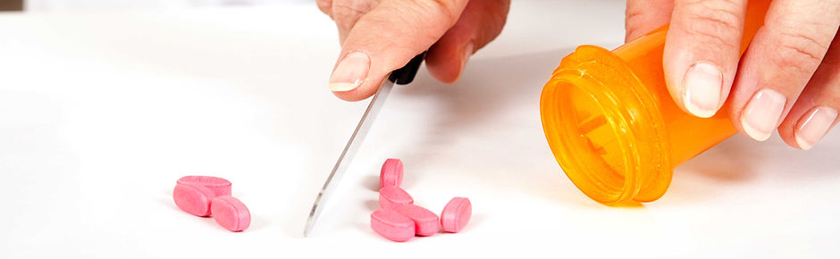 Pharmacist cutting pills
