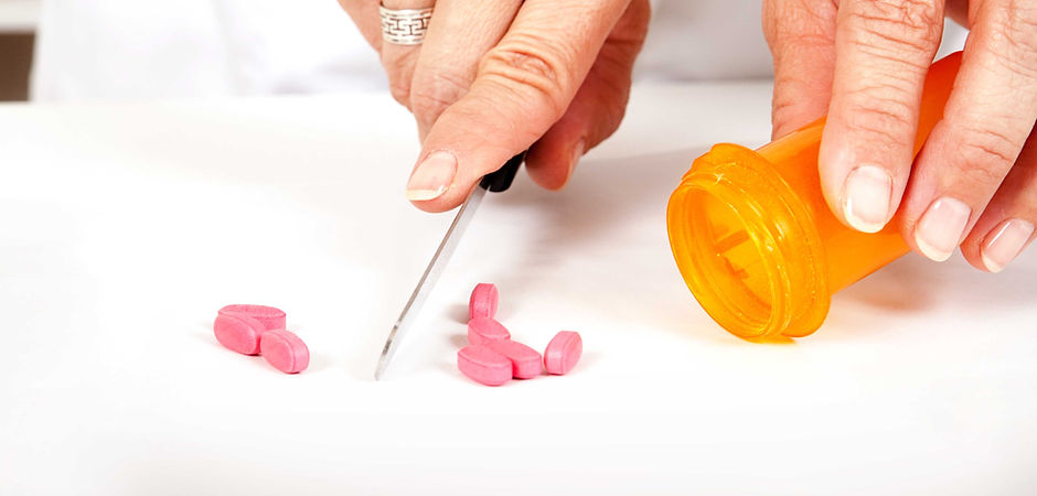 Pharmacist cutting pills