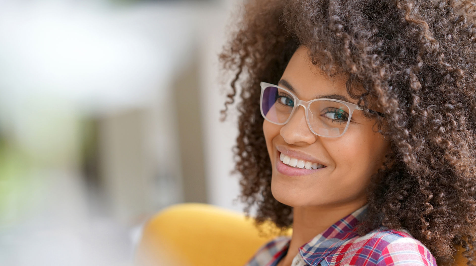 Attractive mixed race woman with eyeglasses relaxing in armchair.jpg