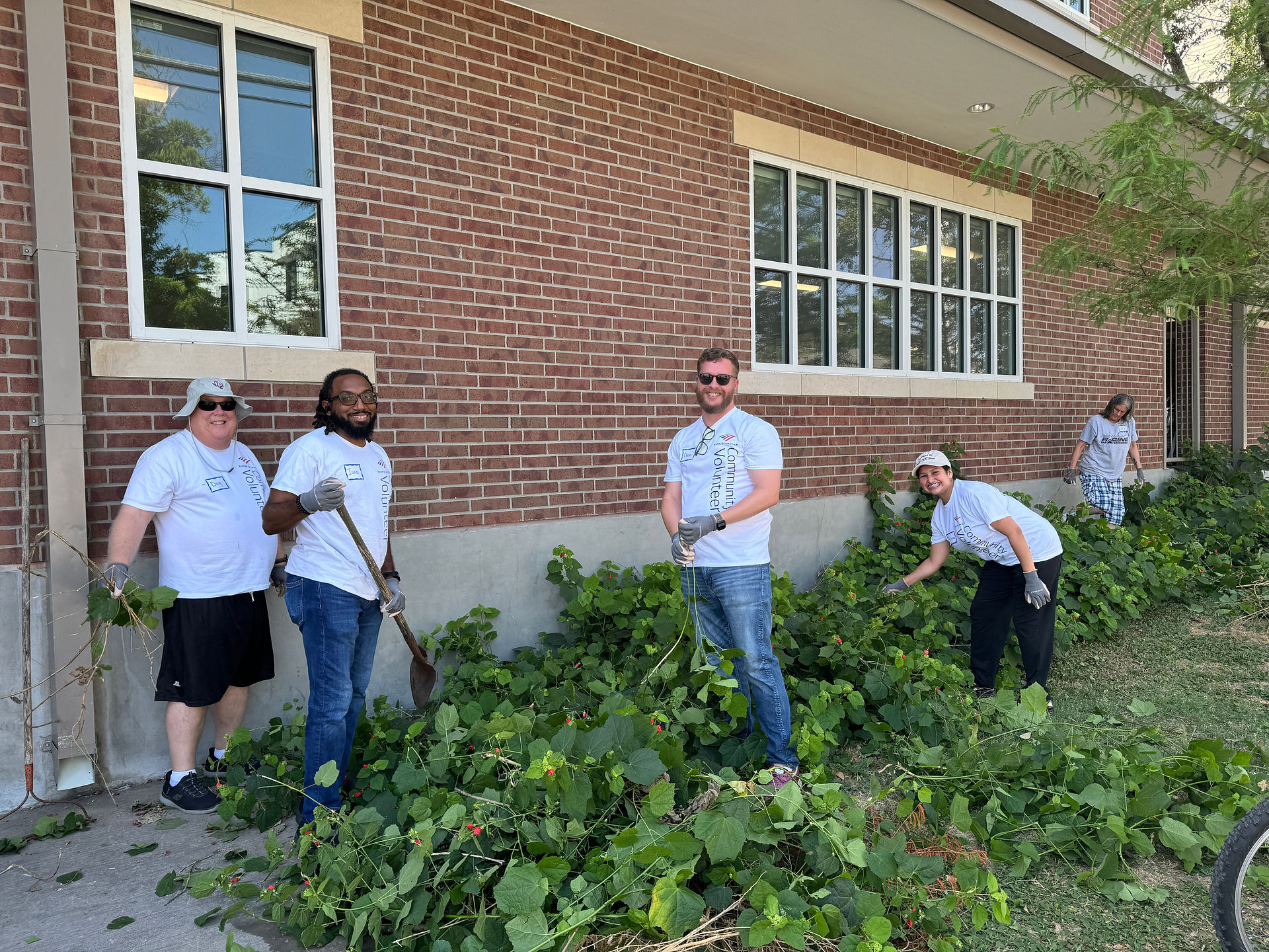 Bank of America volunteers pause to take a photo while digging out the old foliage.