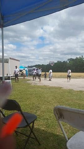 Outdoor gathering with people, viewed from inside a tent