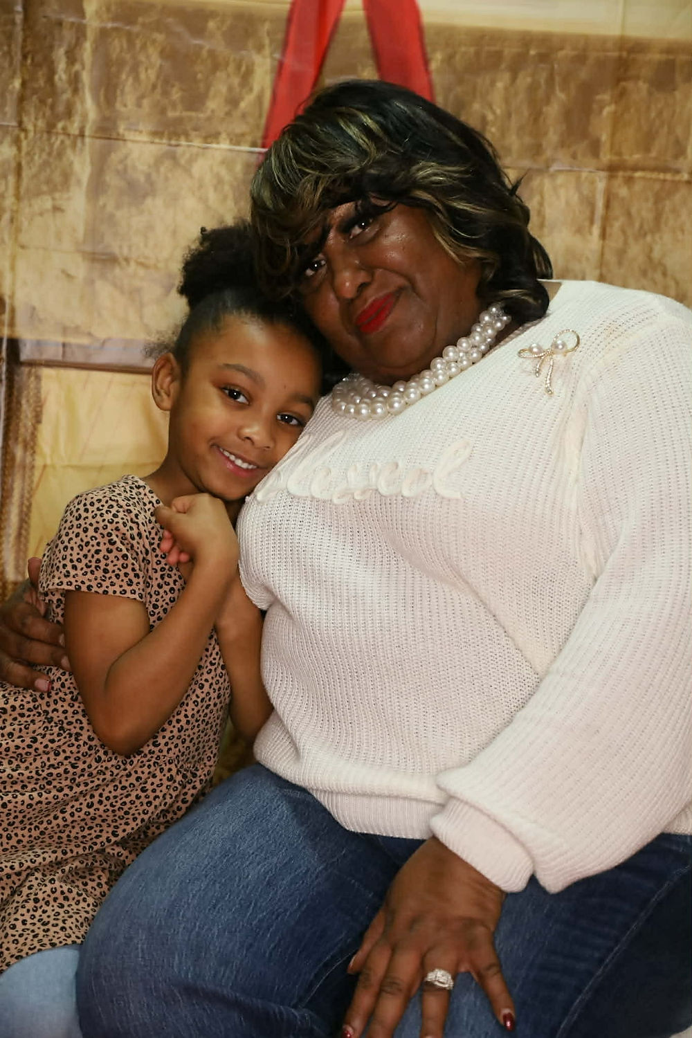 Woman and young girl embracing, smiling at camera