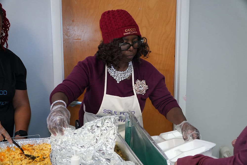 Woman wearing a red beanie and 'SSLA FOOD' apron serves food