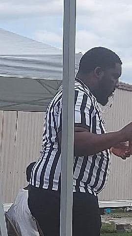 Man in black and white striped referee shirt