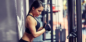 woman-flexing-arm-muscles-on-cable-machi