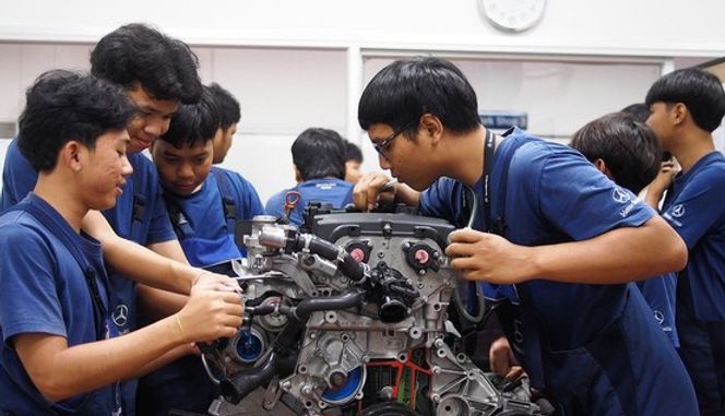 Vocational students study motion sequence of different engine parts at a Mercedes-Benz tra