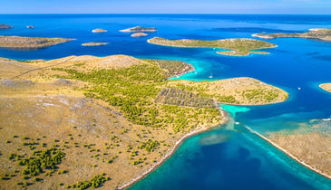 Turquoise water in Kornati with luxury boat anchored nearby