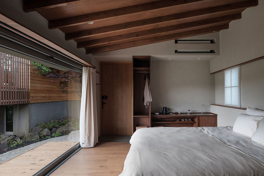 제  주 목조주택의 아늑한 침실: 넓은 창문과 목재 천장