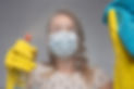 Focus on glass. Cleaning with viruses and bacteria at home. The girl in the mask cleans wi