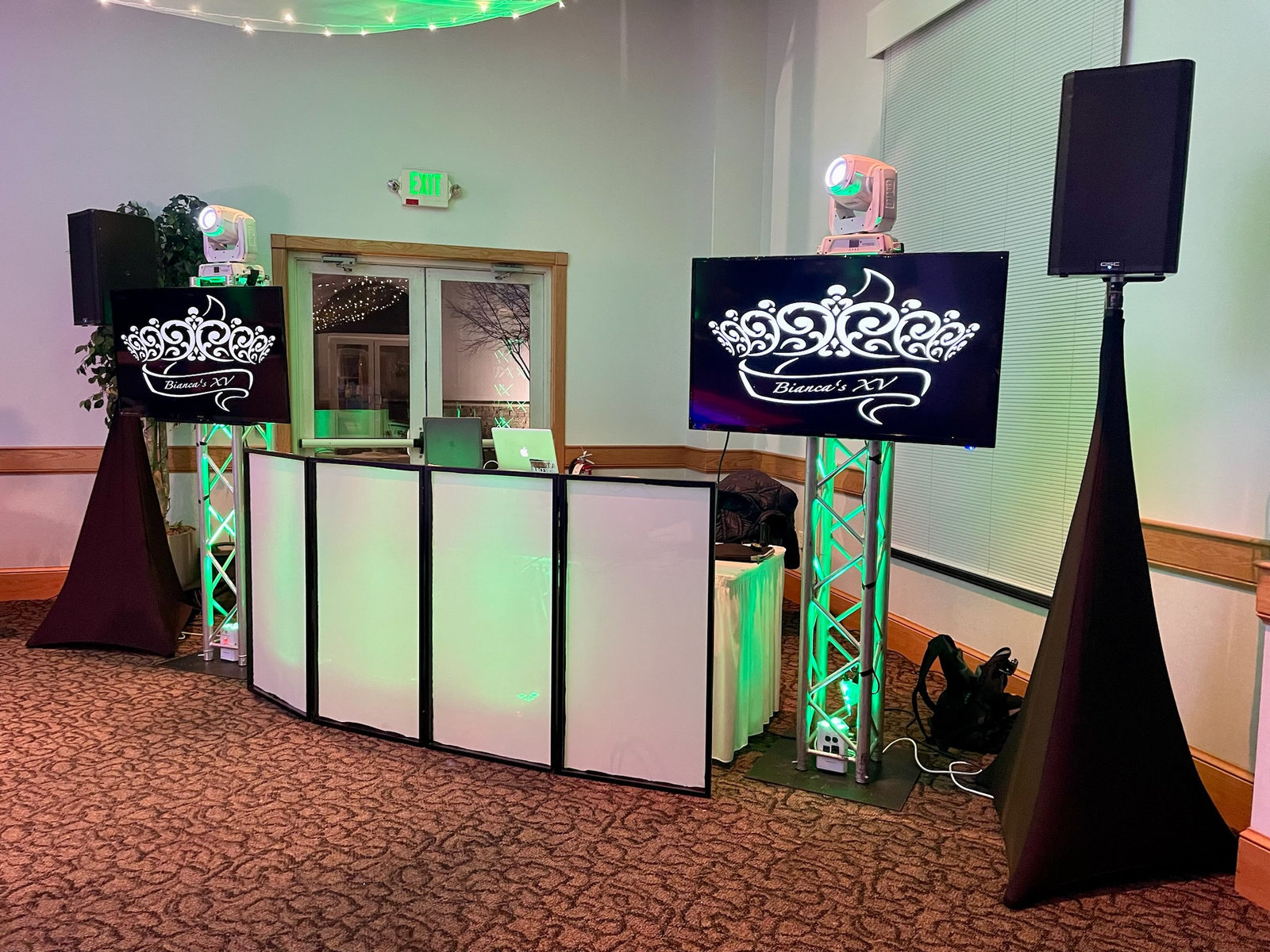 White DJ facade with two screens on truss showing a custom quinceañera monogram, moving heads on top