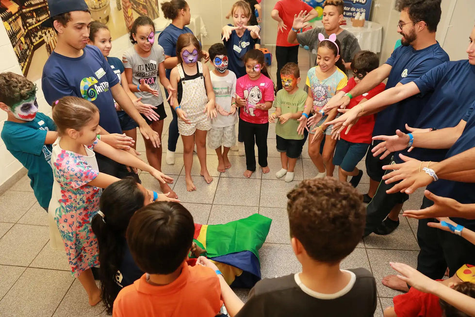 Crianças se divertindo com recreadores em evento da empresa.