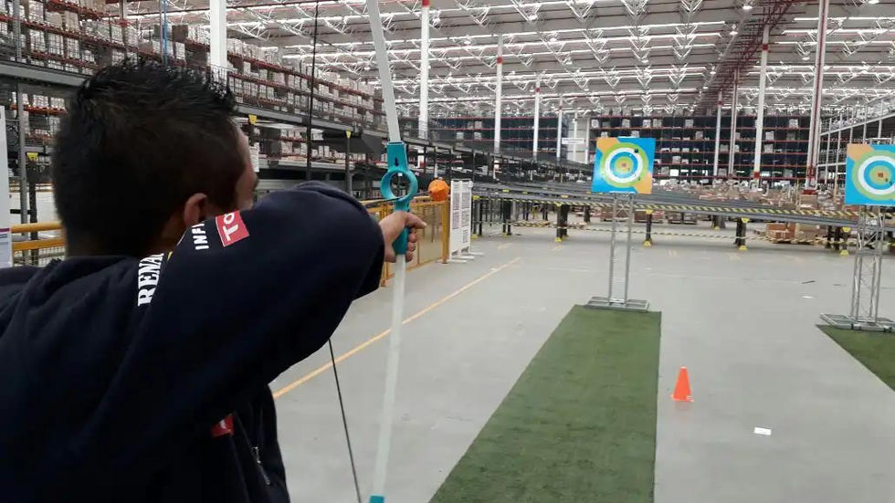 Criança praticando tiro ao alvo com arco e flecha de brinquedo.