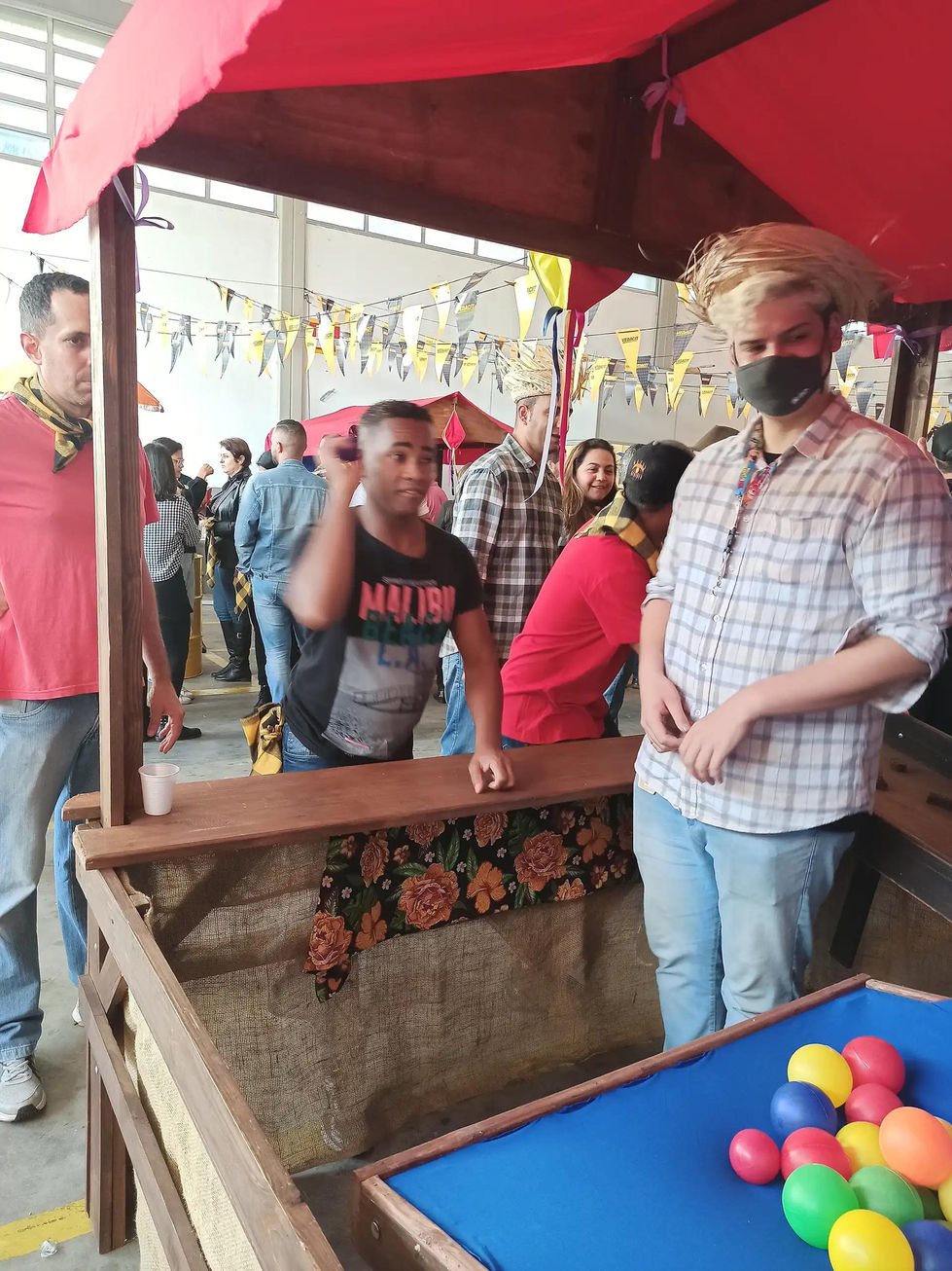 Funcionários participando de brincadeiras tradicionais em festa junina da empresa.