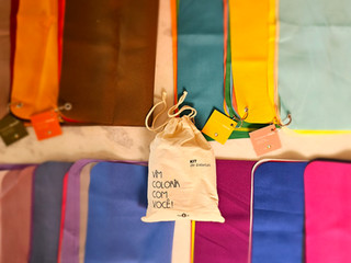 Várias toalhas coloridas, com etiquetas e saco de tecido, para você. Repertório de produtos.
