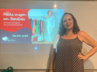 Mulher em frente à tela com texto, Repertório, e fundo branco. HOME