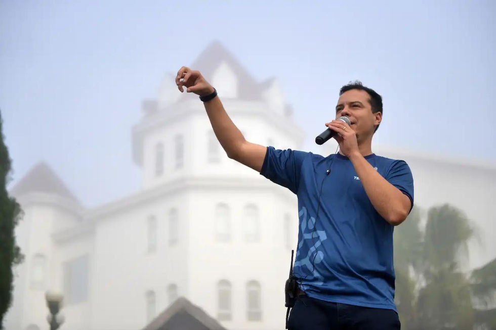 Apresentadores animando plateia durante convenção empresarial.