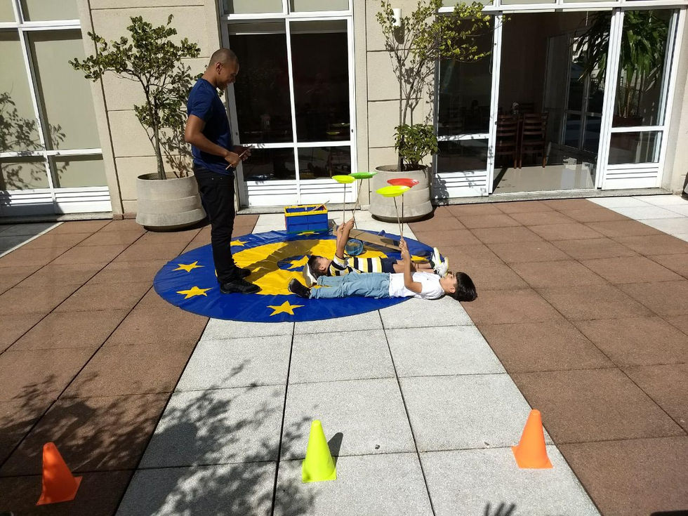 Crianças aprendendo técnicas circenses em oficina prática.