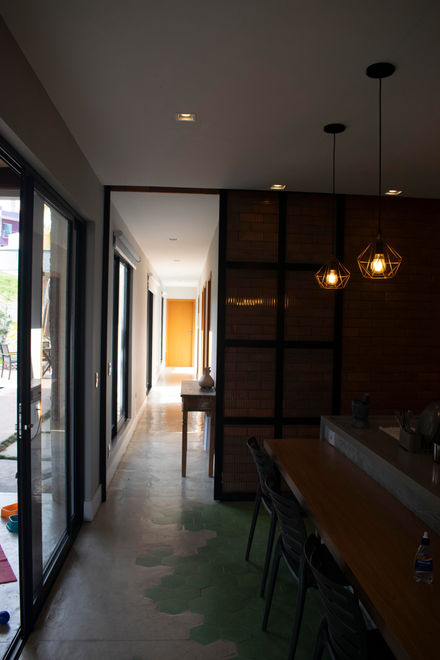 Um ambiente interno moderno que combina sala de estar, cozinha e sala de jantar integradas. O espaço possui estantes, uma mes