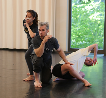 Theatre ensemble in circle formation practicing group awareness and collective rhythm in physical theatre training Berlin Germany