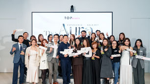 This is a group photograph from the TopBeauty event, with the backdrop screen displaying ‘TOPBEAUTY EXPERIENCE GALA 2025 The Aura’. Approximately twenty guests and staff members stand smiling on stage for the group shot, many holding placards bearing the words “TOPBEAUTY”, ‘Beauty Aura’ or ‘Experience Gala’, alongside trophies. The atmosphere is both lively and professional.