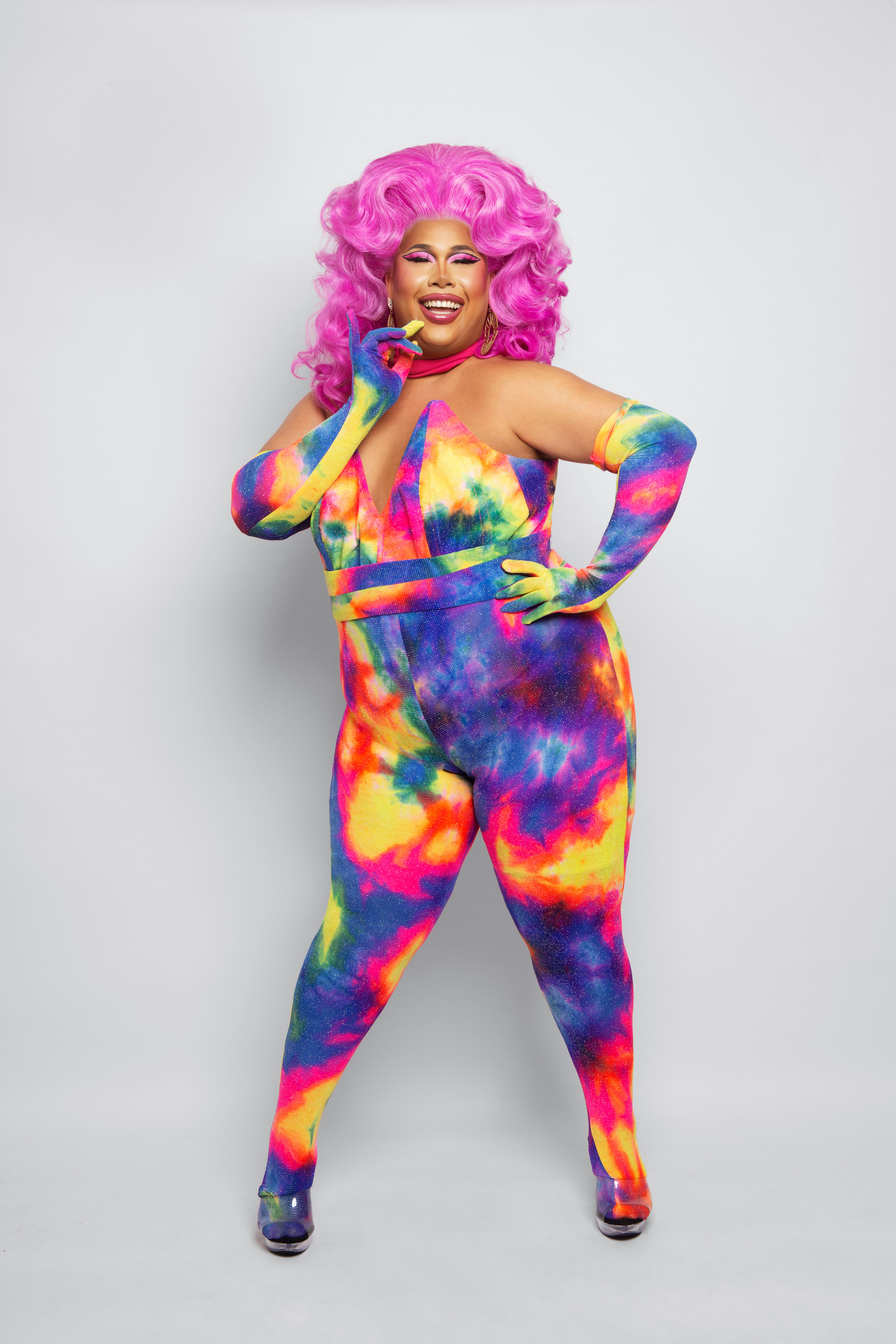Coco Jumbo with pink hair in a rainbow catsuit