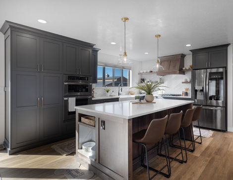 a kitchen with a built in dog feeding station, modern floating shelves, chevron backsplash and custom stove hood