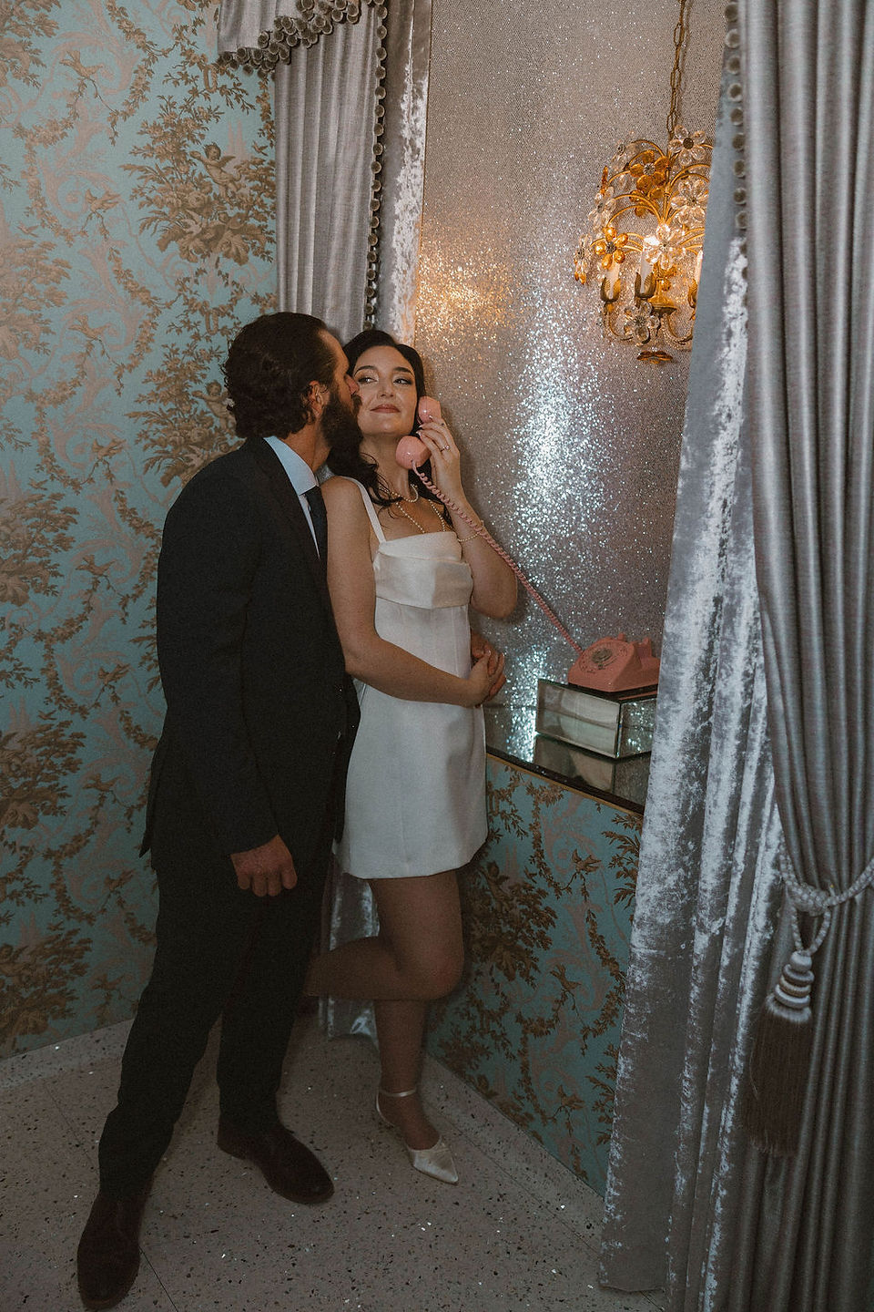 portrait of the groom kissing the bride on the cheek