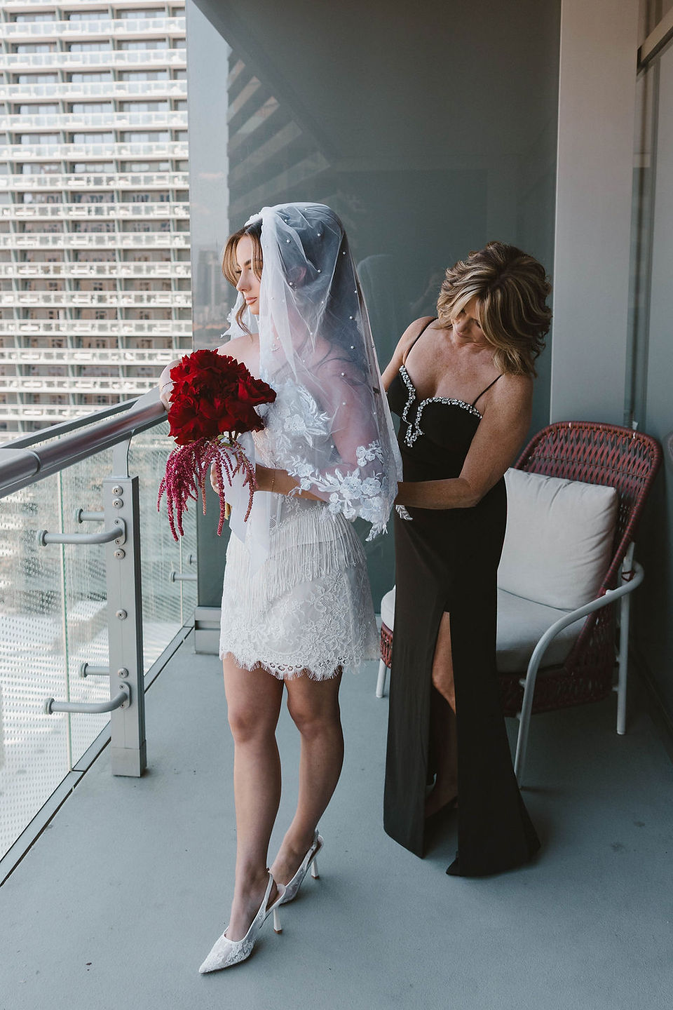 mother of the bride helping her with the wedding dress