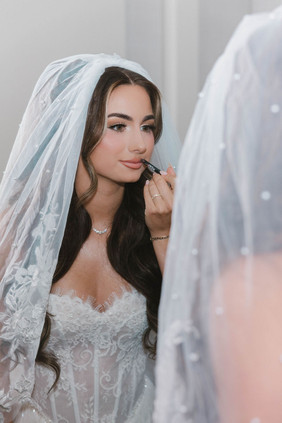 bride touching up her makeup before her ceremony