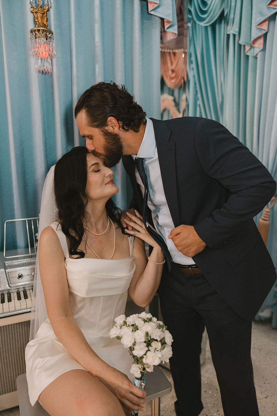 groom kissing the bride on the forehead