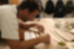 Homem realizando trabalho artesanal em folhas madeira