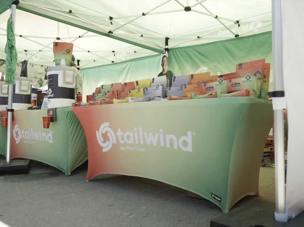 stretch table covers and branded event tent creating a professional product sampling display