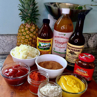 All ingredients needed to make pineapple barbecue sauce: pineapple, molasses, Worcestershire sauce, apple cider vinegar, chipotles, onions, ketchup, mustard, coconut sugar, paprika, and salt