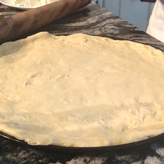 uncooked pizza dough rolled onto around pizza crust