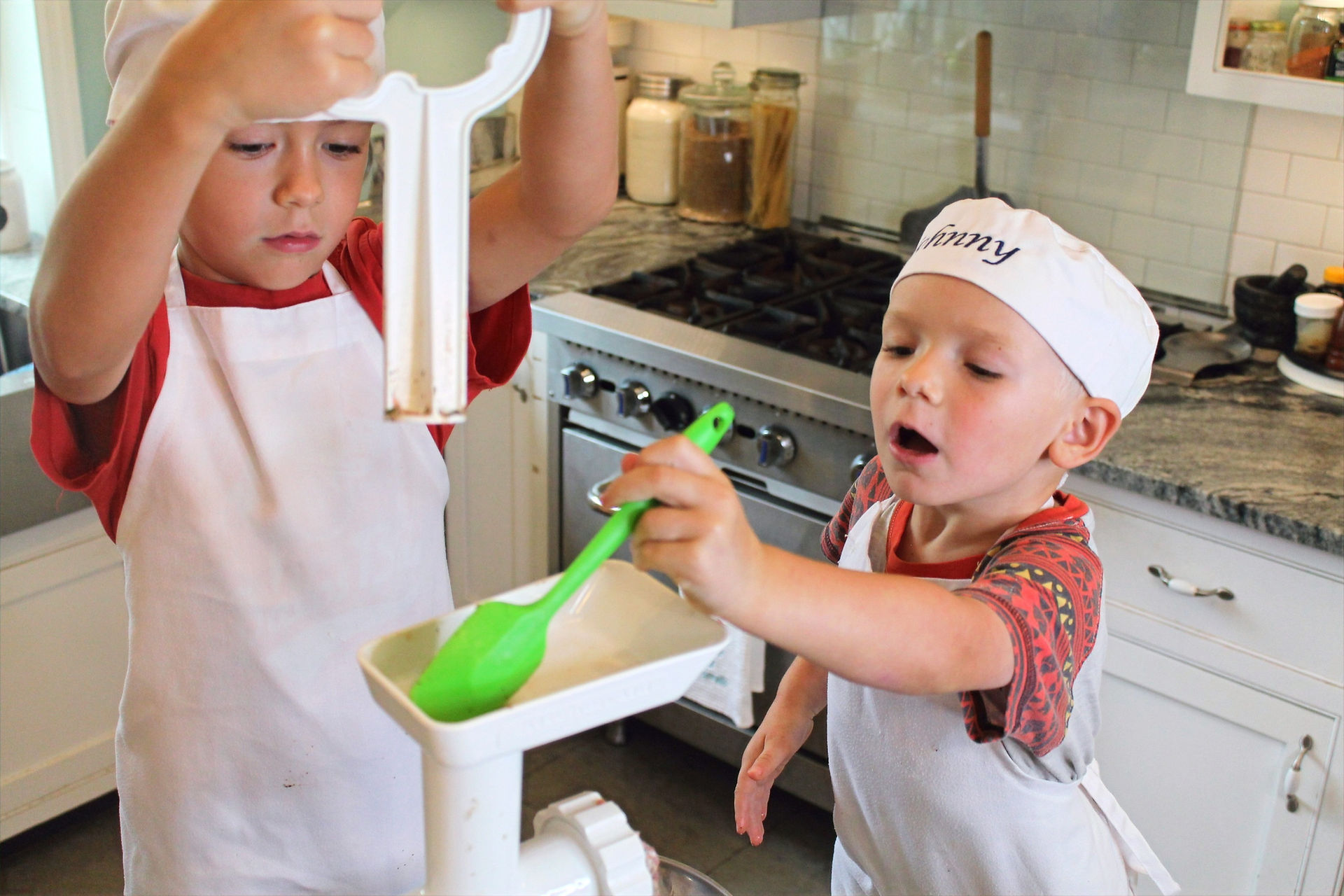 two boys working on a meat grinding 