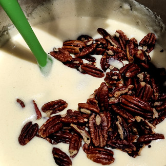 pecans added into a bowl with cream