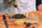 olive oil pouring over black olive tapenade