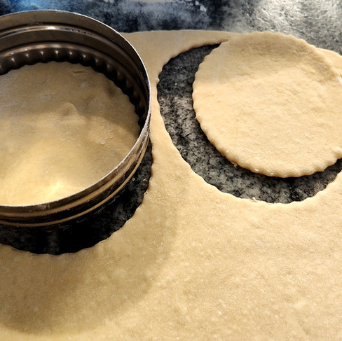 cutting dough with a circle cookie cutter