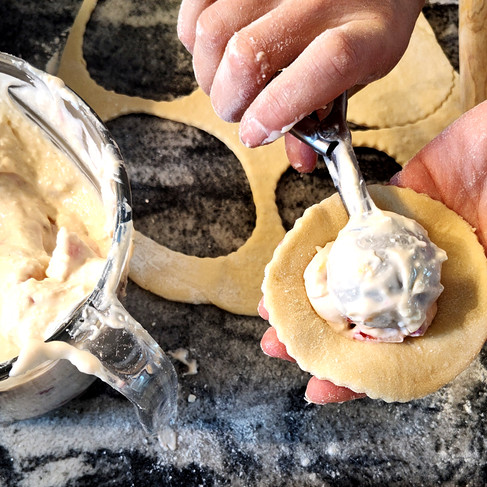 placing a cheesy filling on middle of one circle