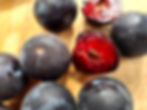 apriums on a wooden board, one fruit is broken in half