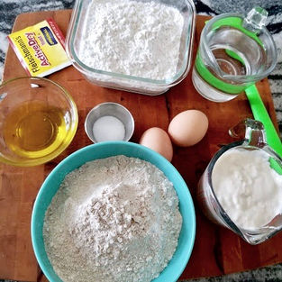 Ingredients for sourdough English muffins: flour, yeast, whey, salt, starter, olive oil, and egg whites