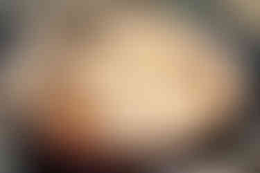 adding duck into a pan with bubbling sauce using kitchen tongs