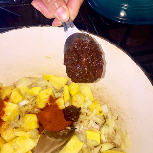 Adding ingredients to the pot to make pineapple barbecue sauce