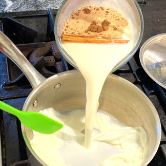 pouring milk with spices into a sauce pot