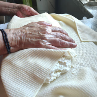 folding the muslin cloth over the cheese