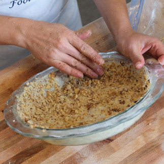 pressing nuts into pie dish