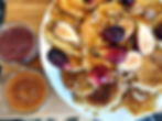 figs, pancake and two Mason jars with sauce