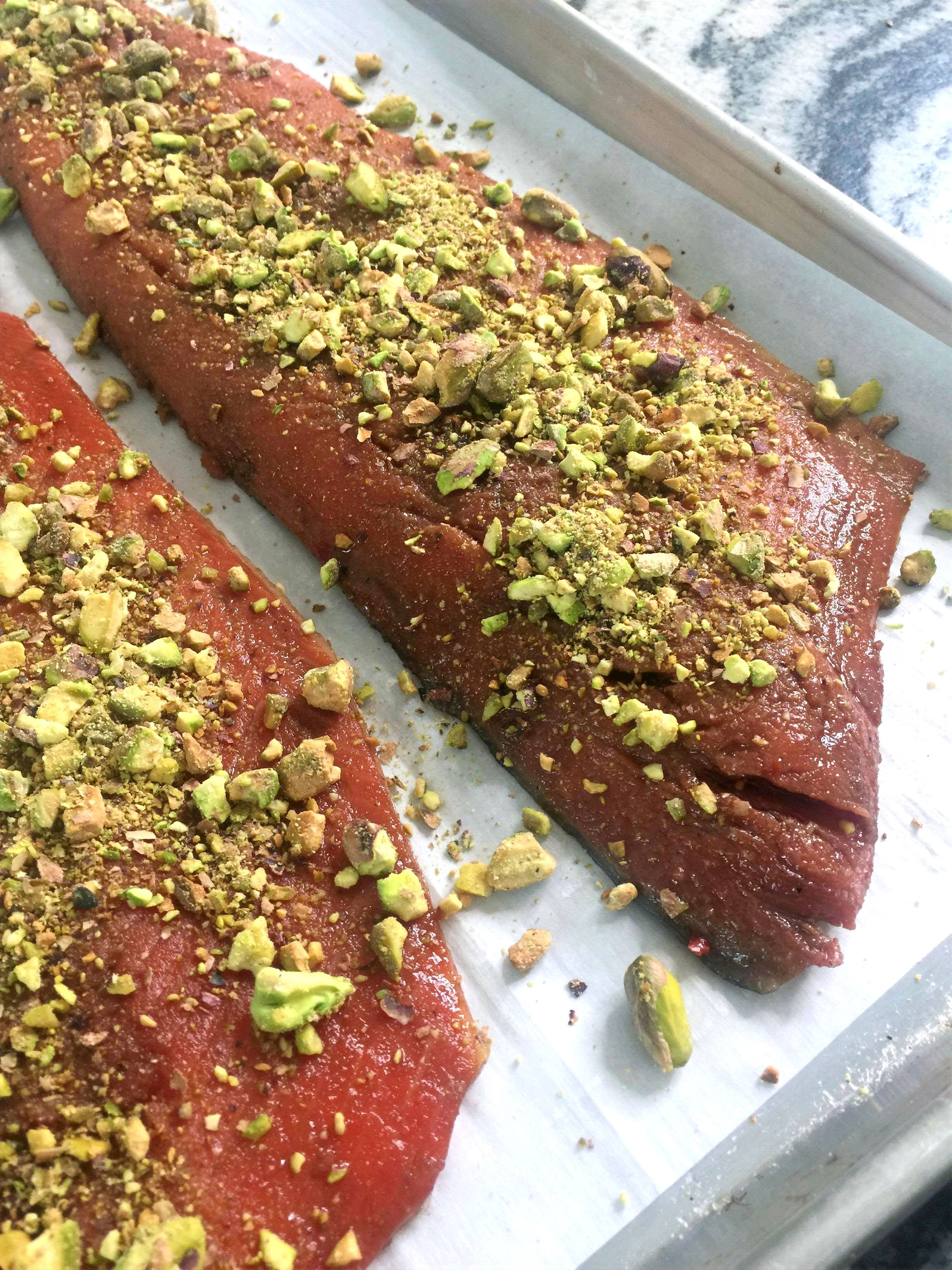 Two salmon fillets baked with whiskey marinade and covered with crushed pistachios