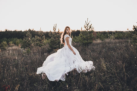 bride in wedding white dress walking on meadow