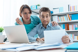 Stressed young couple checking bills, ta